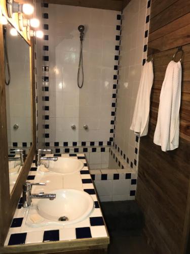 a bathroom with a white sink and a shower at Roatan Bed & Breakfast Apartments in West End