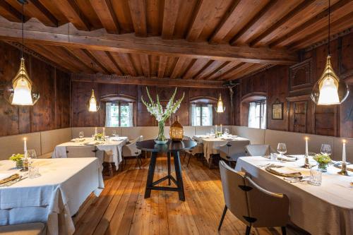 a dining room with tables and chairs and wooden ceilings at Der Böglerhof - pure nature spa resort in Alpbach