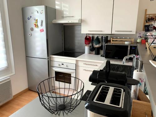  La cuisine est équipée de placards blancs et d'un réfrigérateur. dans l'établissement Appartement Cosy à quelques minutes du Centre, à Châlons-en-Champagne