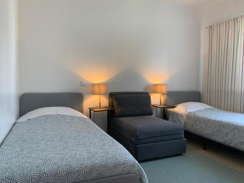 トロイアにあるAtlantic Blueのベッドルーム1室(ベッド1台、椅子、ランプ付)