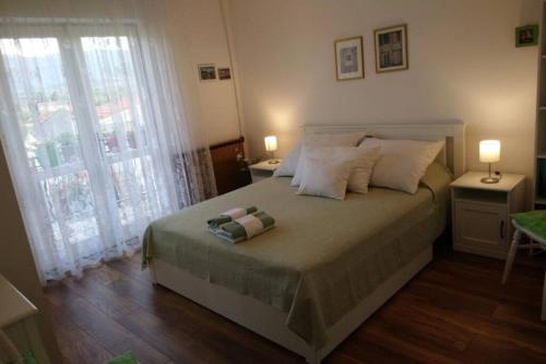 a bedroom with a large bed with two lamps at Apartman Nađa in Vrboska