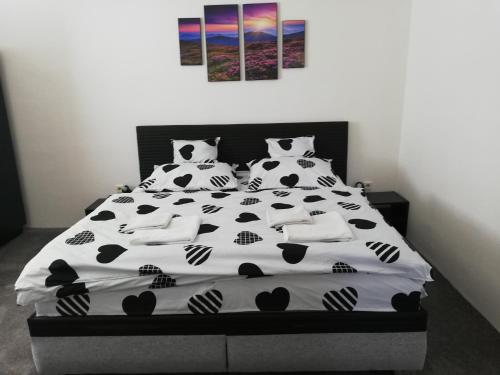 a bedroom with a black and white bed with pillows at Penzión Baltazár in Liptovská Lúžna