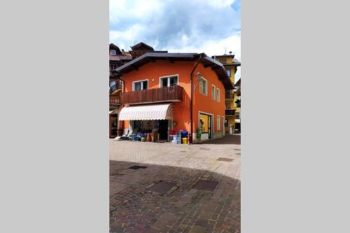 an orange building in the middle of a street at CASA CHECHE - Nel cuore di Fiera di Primiero in Fiera di Primiero