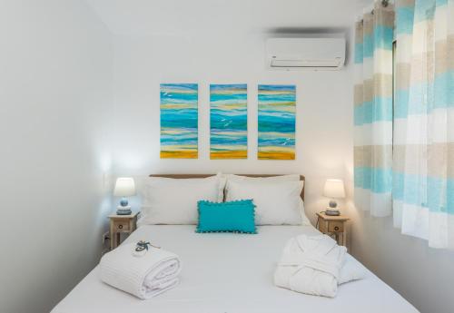 1 dormitorio con 1 cama blanca y 2 lámparas en Waves Apartments Melody Glyfada en Glyfada