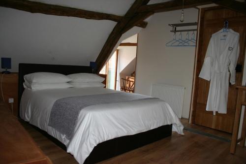 sypialnia z łóżkiem i szlafrokiem wiszącym na ścianie w obiekcie Belonga Mick w mieście Béthines