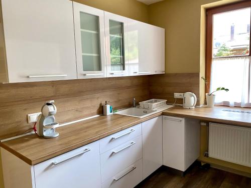uma cozinha com armários brancos e um lavatório em ALFA em Demanovska Dolina