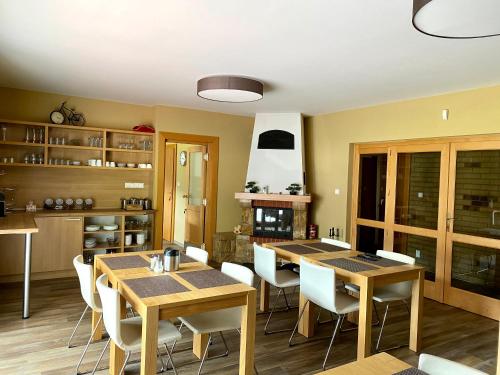 uma cozinha e sala de jantar com mesas e cadeiras de madeira em ALFA em Demanovska Dolina