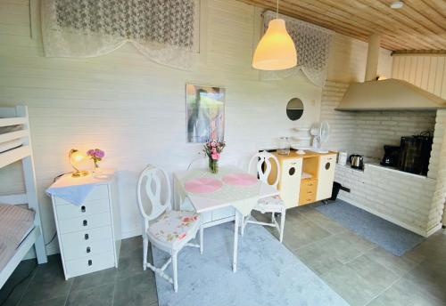 a dining room with a table and chairs and a kitchen at Nösund Guestroom in Nösund
