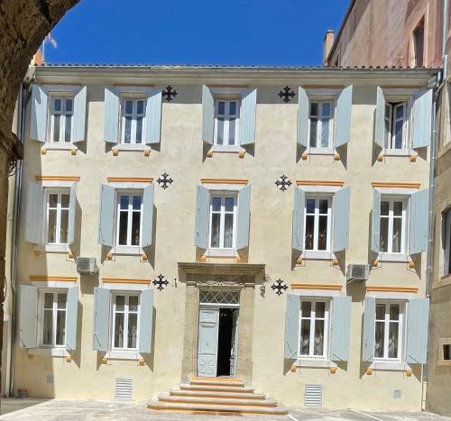 a building with blue and white windows and a door at Chambre Lyre Maison de L'Église du Couvent in Narbonne