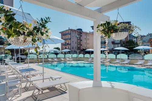 uma piscina com espreguiçadeiras e um edifício em Hotel San Giorgio em Cesenatico