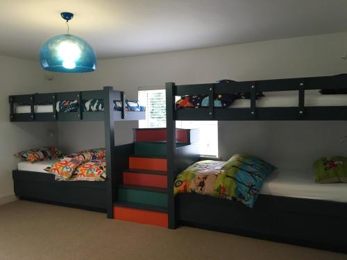 a room with two bunk beds and a room with two beds at Ealu Mor - Ballylickey, West Cork luxury by the sea! Now with Wifi! in Bantry