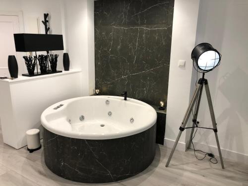 a large bath tub in a room with a camera at Black and White Suitte "Plaza" in Noja