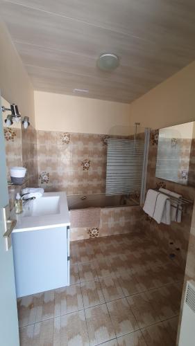 La salle de bains est pourvue d'un lavabo blanc et d'une baignoire. dans l'établissement Appartement la tour du sel, à Aigues-Mortes