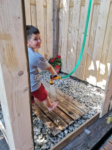 a young boy playing with a hose in a fence at Romantická chatka so saunou v prírode in Turany