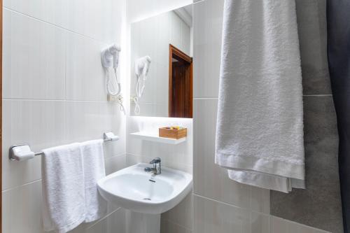 a white bathroom with a sink and a mirror at Hostal La Costa in El Ejido