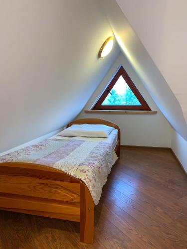 a bedroom with a bed in a attic with a window at Na Wierchu in Bukowina Tatrzańska