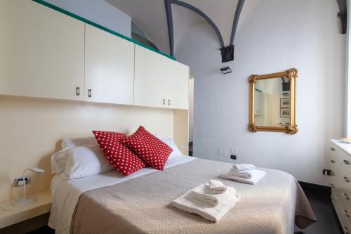 a bedroom with a bed with red and white pillows at La Casa delle Volte in La Spezia