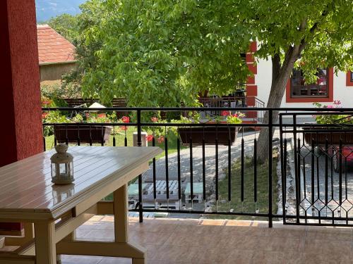 a wooden table sitting on a balcony with a tree at Guest Accommodation Zone in Niška Banja