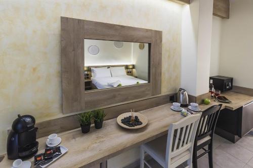 Zimmer mit einem Tisch, einem Spiegel und einem Bett in der Unterkunft Hotel Odysseas in Polychrono