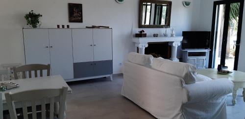 a living room with a white couch and a table at Hannas Paradise - Villa Hanna in Skafidia