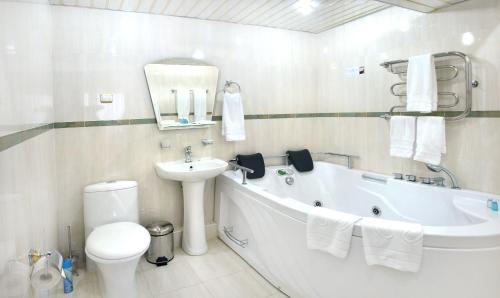 a bathroom with a tub and a sink and a toilet at Inturist Hotel in Pyatigorsk