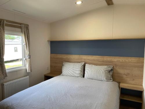 une chambre avec un grand lit avec une tête de lit bleue dans l'établissement Turlin Valley, à Poole