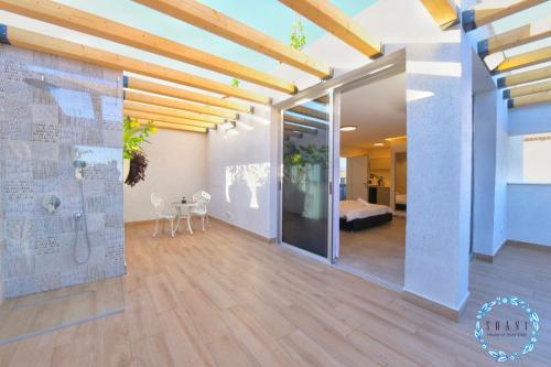 a living room with a large glass door and a bedroom at Shani House Of Style SEATARA VILLA in Eilat