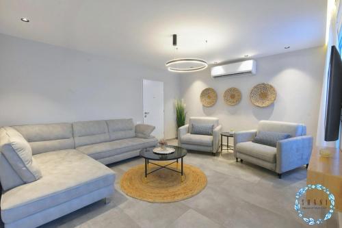 a living room with a couch and two chairs and a table at Shani House Of Style SEATARA VILLA in Eilat