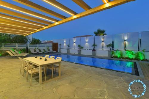 a patio with a table and chairs next to a pool at Shani House Of Style SEATARA VILLA in Eilat