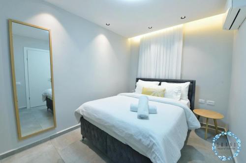 a bedroom with a large bed and a mirror at Shani House Of Style SEATARA VILLA in Eilat