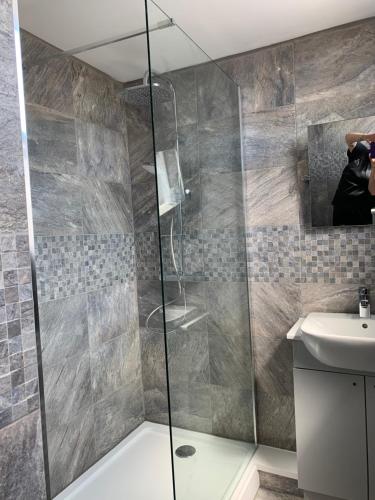 a bathroom with a glass shower and a sink at The White Hart in Llantwit Major