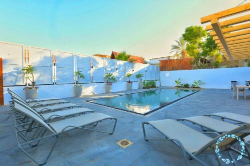 a patio with chairs and a swimming pool at Shani House Of Style SEATARA VILLA in Eilat
