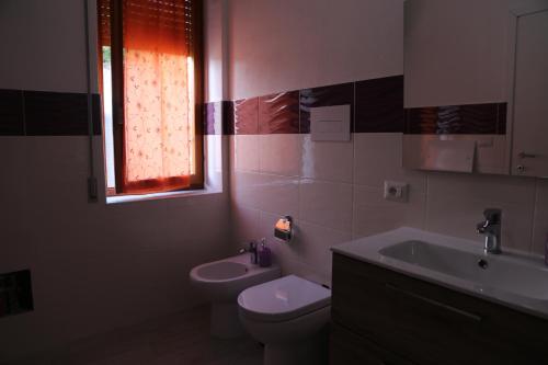 オルゴーゾロにあるS'Orgosaのバスルーム(トイレ、洗面台付)、窓が備わります。