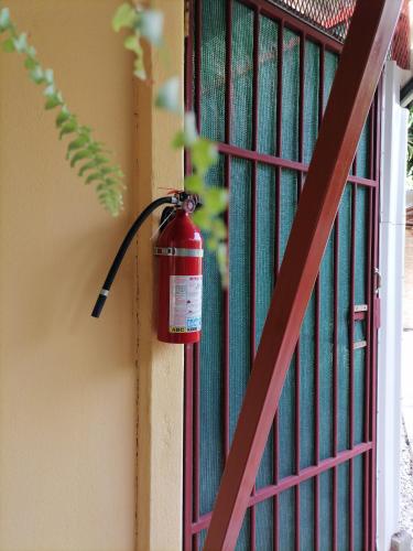a fire extinguisher hanging on the side of a fence at Villa Gabriela, Casa Tucan in Liberia