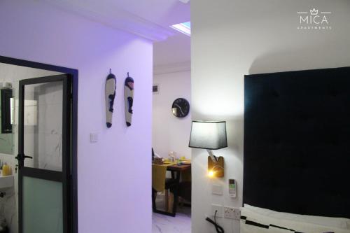 a room with a purple wall with surfboards on the wall at Mica Apartments in Sere Kunda