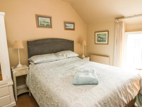 a bedroom with a large bed and two lamps at Silva in Penmon