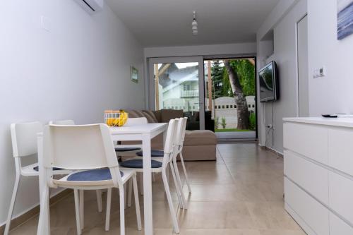 cocina y comedor con mesa blanca y sillas en Zamárdi Árnyas Apartman en Zamárdi