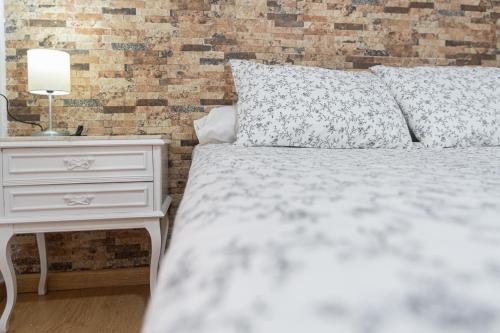 een slaapkamer met een wit bed en een nachtkastje met een lamp bij Apartment La Gitanilla terrace in Cádiz