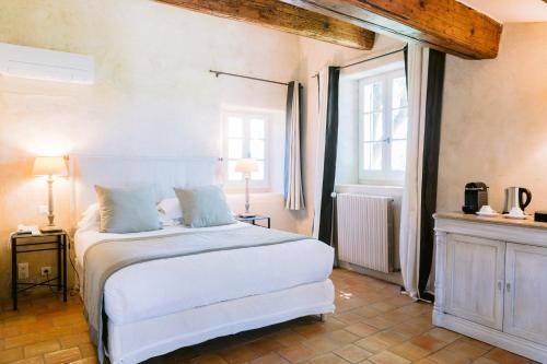 a bedroom with a white bed and a window at Le Mas De La Rose - Teritoria in Orgon