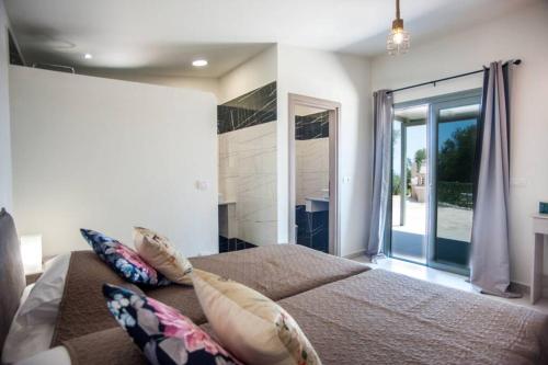 a bedroom with a bed and a large window at Villa Afrato Calma in Trapezaki-private pool -2 BR in Trapezaki