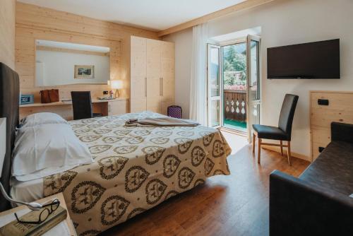 科爾蒂納丹佩佐的住宿－梅娜蒂酒店，一间卧室设有一张床、一台电视和一个窗口。