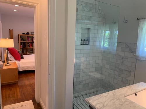 baño con ducha y puerta de cristal en Beautiful airy architect-designed room and brand new private luxe bathroom, en Los Ángeles