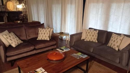 a living room with two couches and a coffee table at Posada Reserva Verde in Bárcena Mayor