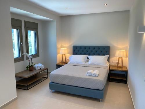 a bedroom with a blue bed with two night stands at Luminous Luxury Apartments in Limenas