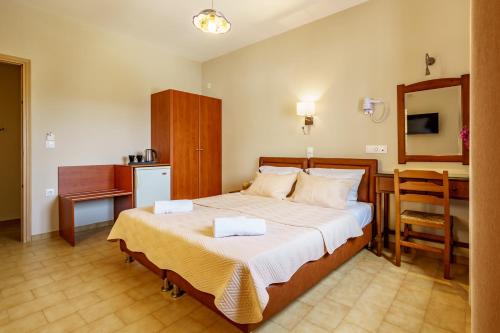 a bedroom with a bed and a table and a chair at Irini studios in Skiros