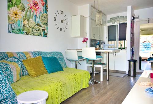 un soggiorno con divano e una cucina di Malibu 2 apartamento con aire acondicionado, campo de tennis y piscina con solarium a Puerto Rico de Gran Canaria