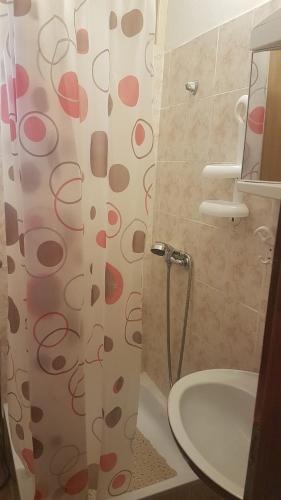 a bathroom with a shower curtain with a toilet and a sink at Kiko 2 in Senj