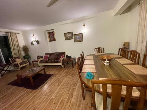 a living room with a wooden table and chairs at The Generals Inn in Bhurban