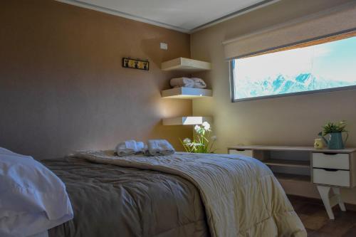 a bedroom with a bed and a window at Potre casas de montaña in Potrerillos