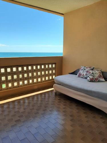 une chambre avec un lit et une grande fenêtre dans l'établissement Face à la mer, au Barcarès